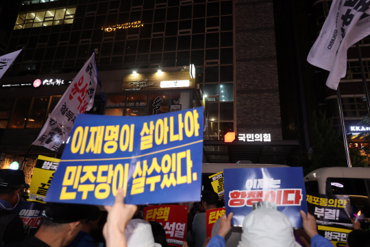 국회에서 이재명 더불어민주당 대표 체포동의안이 가결된 지난 9월21일 오후 '촛불행동' 단체원들이 서울 여의도 국민의힘 당사 앞에서 구호를 외치고 있다.<연합뉴스>